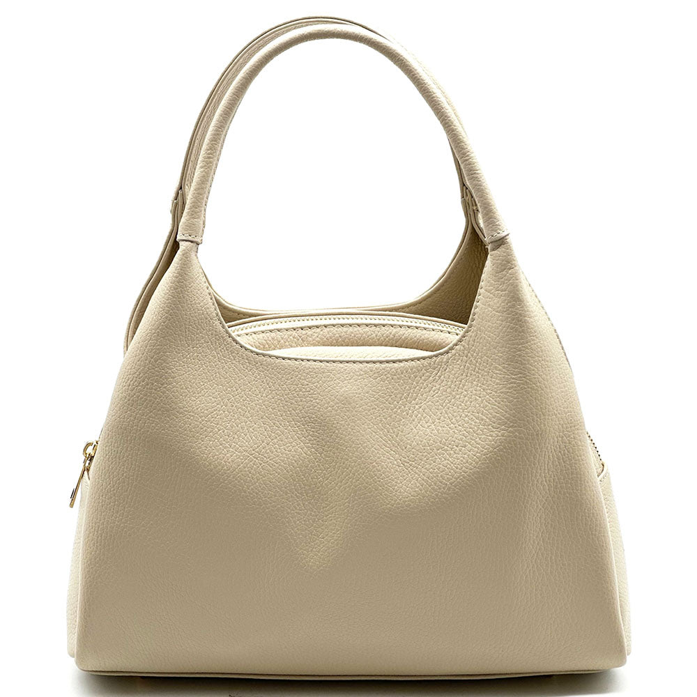 A light beige pebbled leather hobo handbag with dual top handles and a zippered side pocket, shown against a plain white background.