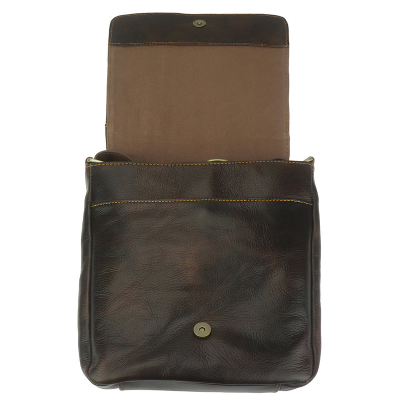 Brown leather bag with open flap showing button closure